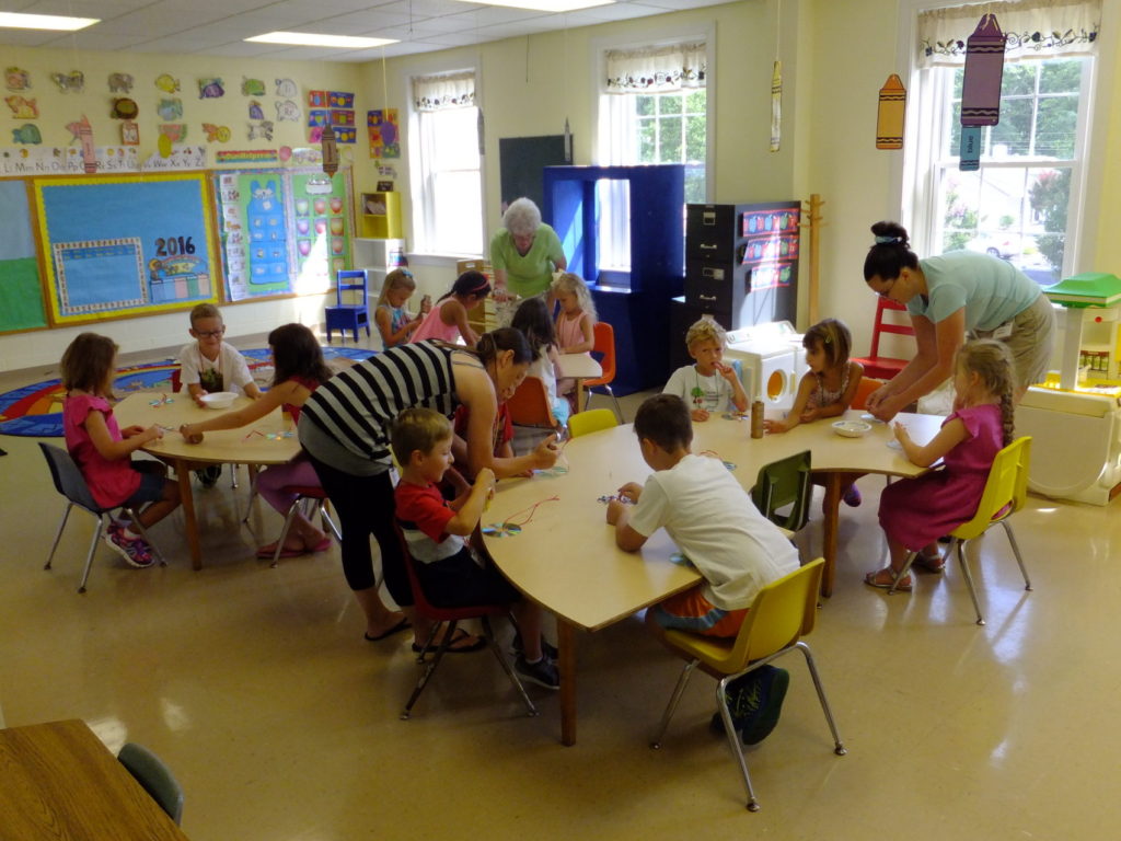 teachers assist children in Sunday school classroom