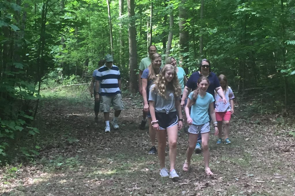 people walk on wooded trail