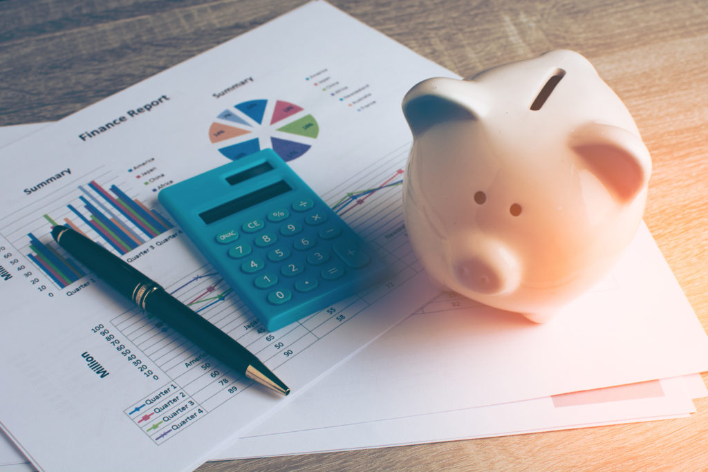 financial charts, calculator, and piggy bank