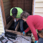 Barry Rae (left) and Betty Williams work together to remove rotted wood