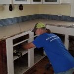 Don Williams removes cabinets in a water-damaged kitchen