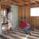 Don Williams (left) and Barry Rae replace floor joists in a room