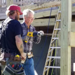 Dick Mahlmann (right) drills bolt holes with a local Ocracoke contractor for a wheelchair ramp the crew constructed